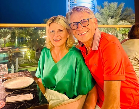 Nadia and Jochen smiling while sitting outdoors in a restaurant with Dubai view